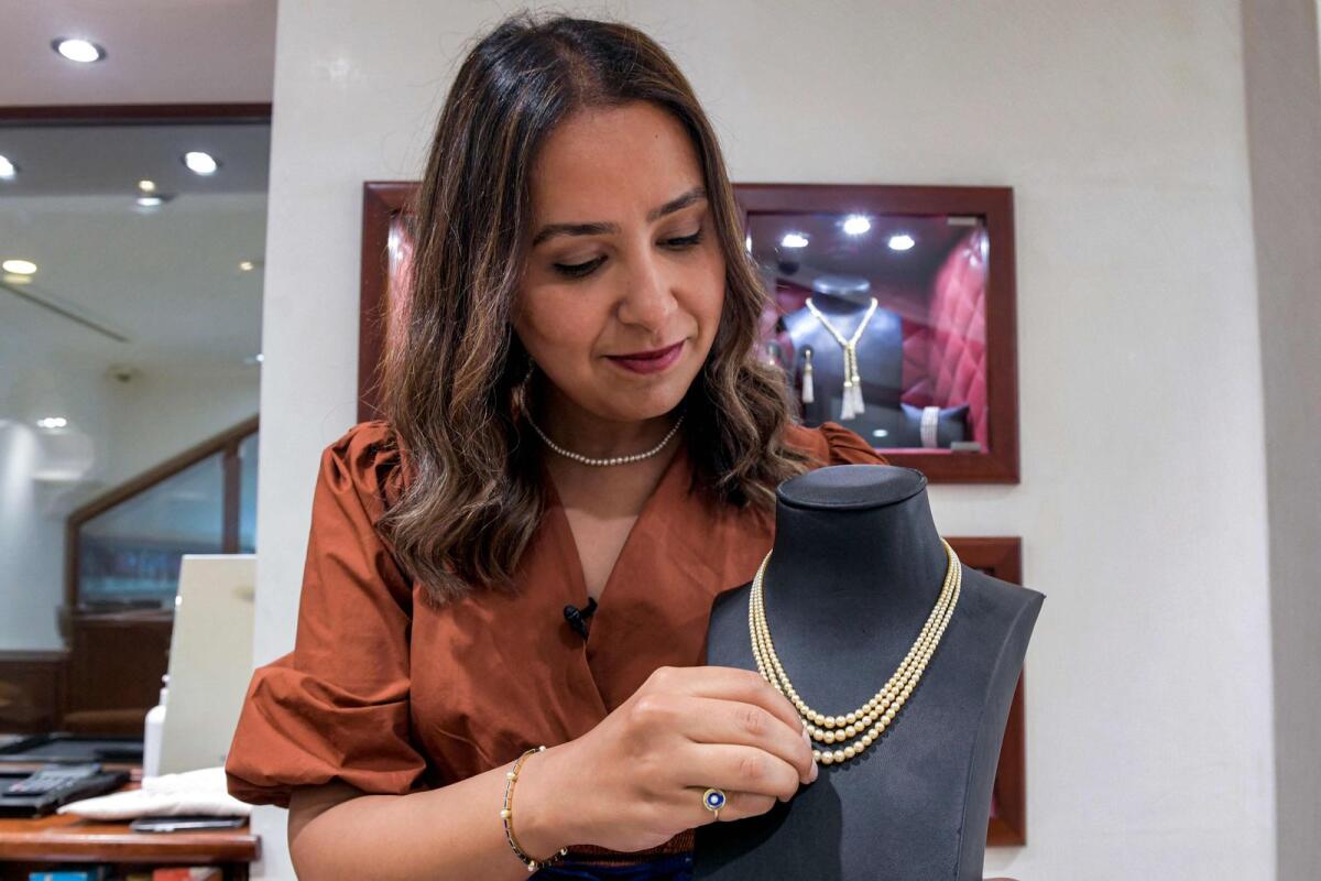 Faten Mattar of Mattar Jewellers presents a natural pearl necklace at the House of Pearls shop in Manama.— AFP