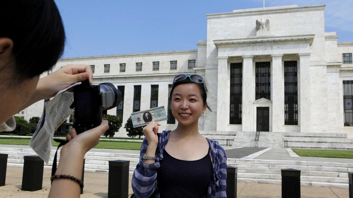 Chinese student Leyna Liu from Shanghai poses with a fake million dollar bill in front of the Federal Reserve building in Washington.