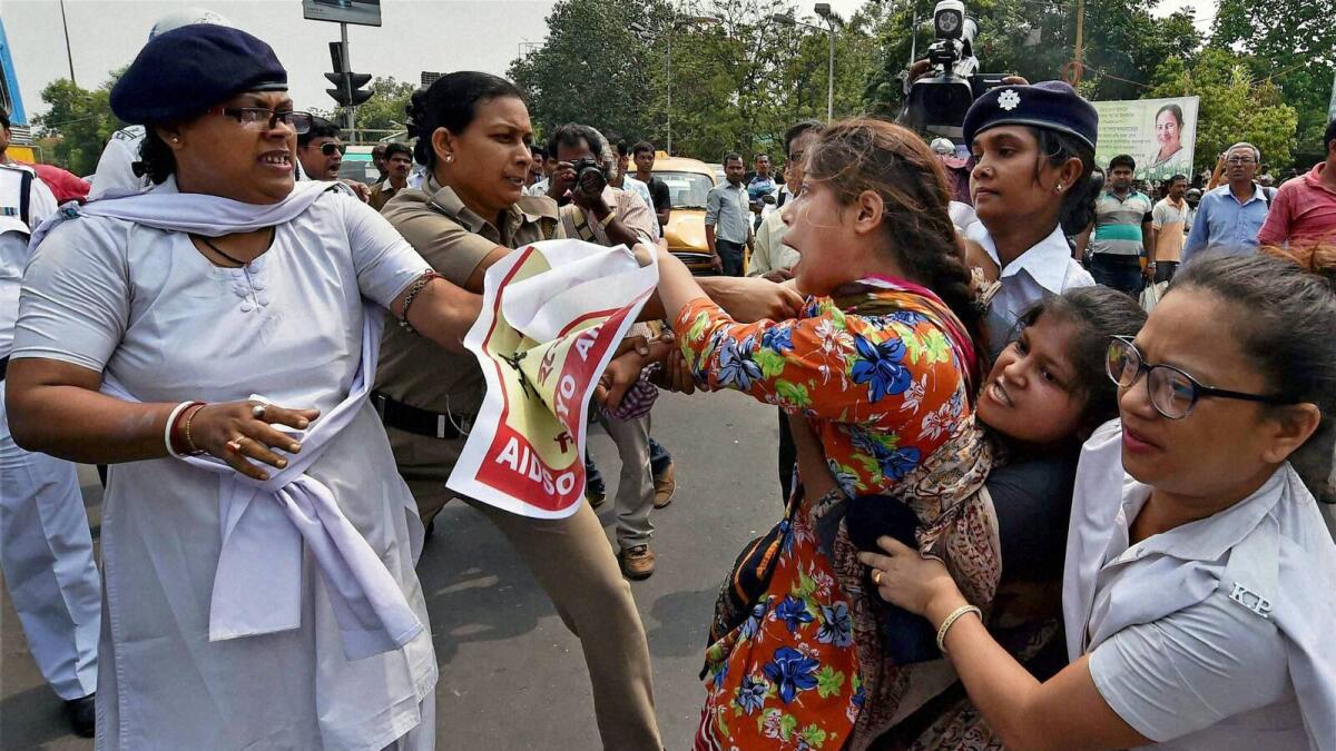 Police detain activists during a protest against the gang rape of a woman in Kolkata on Tuesday.