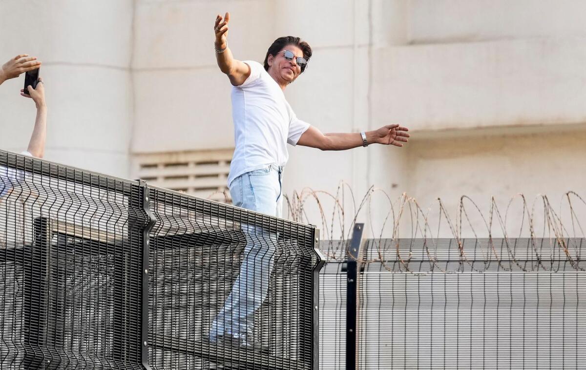 Actor Shah Rukh Khan strikes his signature pose for fans during his 57th birthday celebrations, at his residence Mannat in Bandra, Mumbai on Wednesday. –PTI