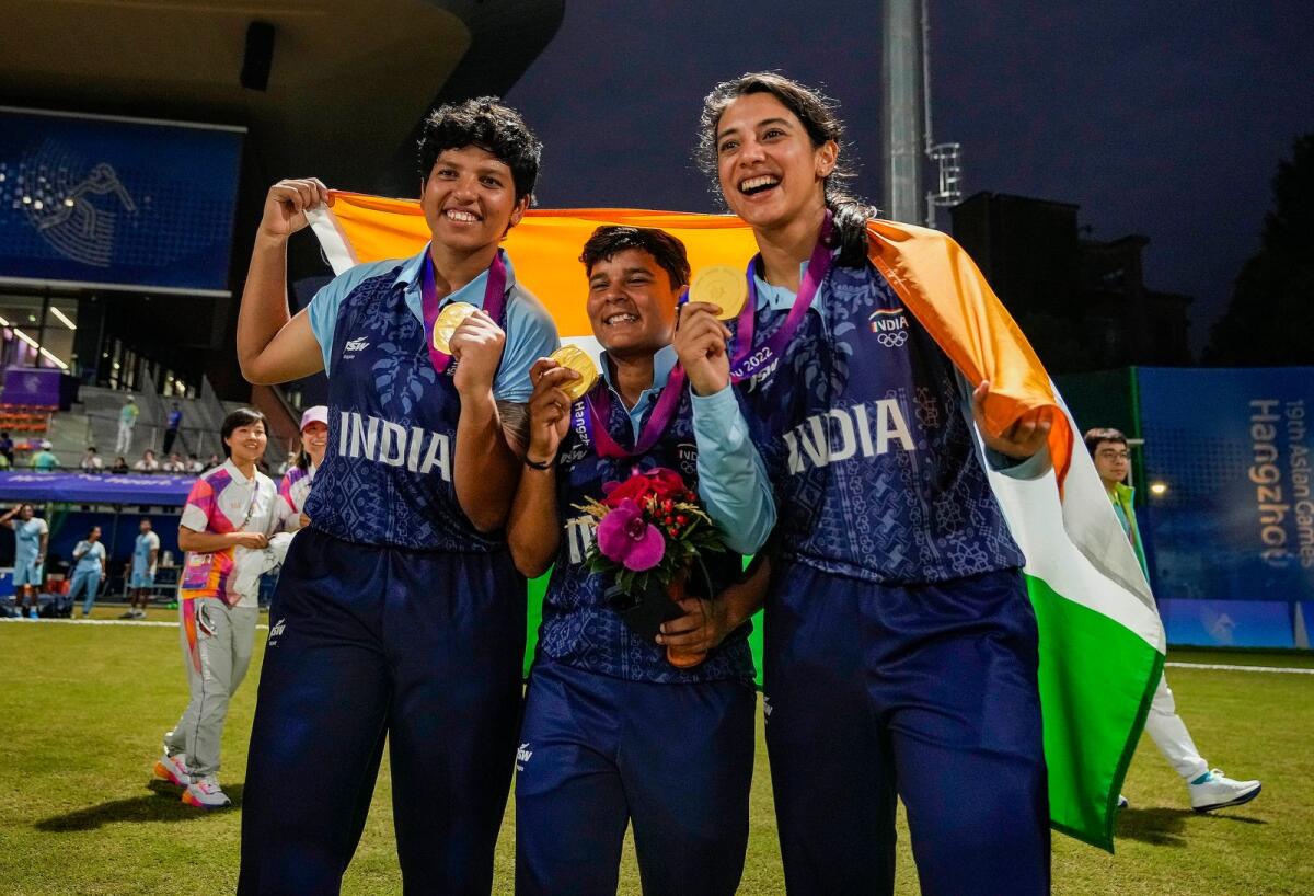 India's Richa Ghosh, Kanika Ahuja and Smriti Mandhana pose for photos after the team's win against Sri Lanka in the gold medal match in women's cricket on Monday. — PTI