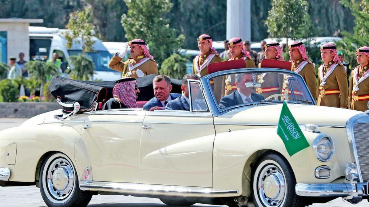 Saudi Arabia’s King Salman bin Abdulaziz and Jordanian King Abdullah sit in a vintage car during a welcoming ceremony  at the airport in the Jordanian capital Amman.