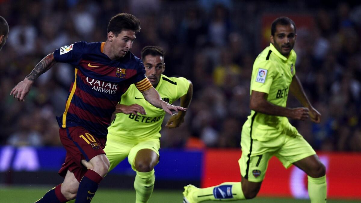 Barcelona’s Lionel Messi (left) gets the better of Levante’s Verza. 