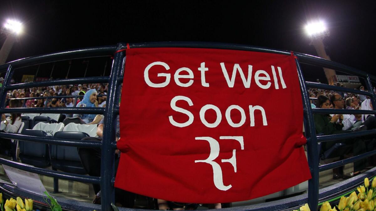 A banner for Roger Federer to get well soon is displayed during the match between Serbian Novak Djokovic and Tunisian Malek Jaziri in Dubai in 2016. — KT file