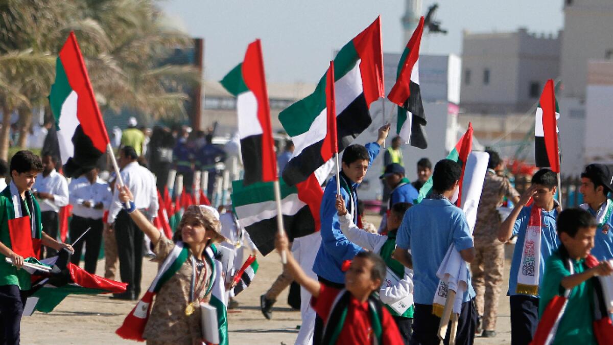Kids holding UAE flag during the 46th UAE National Day carnival organized by Ajman police at Ajman Corniche on Wednesday is a part of 46th UAE National Day Celebrations.