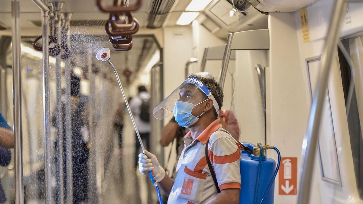 A Delhi Metro employee sanitises a coach as part of preparations ahead of the resumption of metro services from Sept. 7 with restrictions, in New Delhi, India. Photo: PTI
