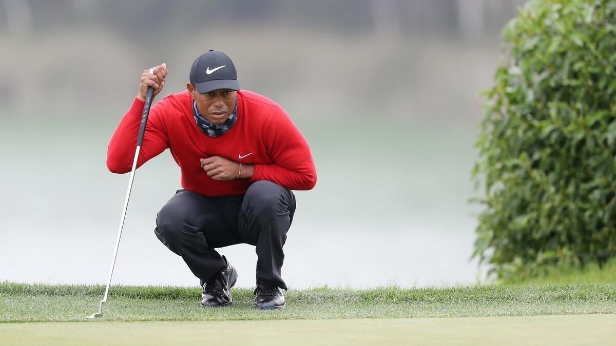 Tiger Woods of the United States lines up a putt on the 18th green