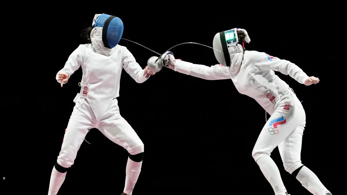 Aizanat Murtazaeva of the Russian Olympic Committee (right) and Sun Yiwen of China compete in the women's individual Epee semifinal competition. — AP