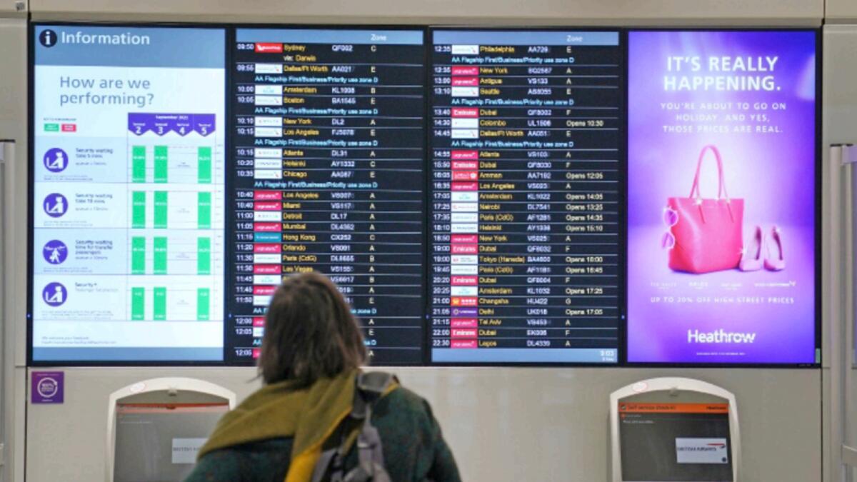 A passenger looks at a departures board at London Heathrow Airport's T3. — AP file