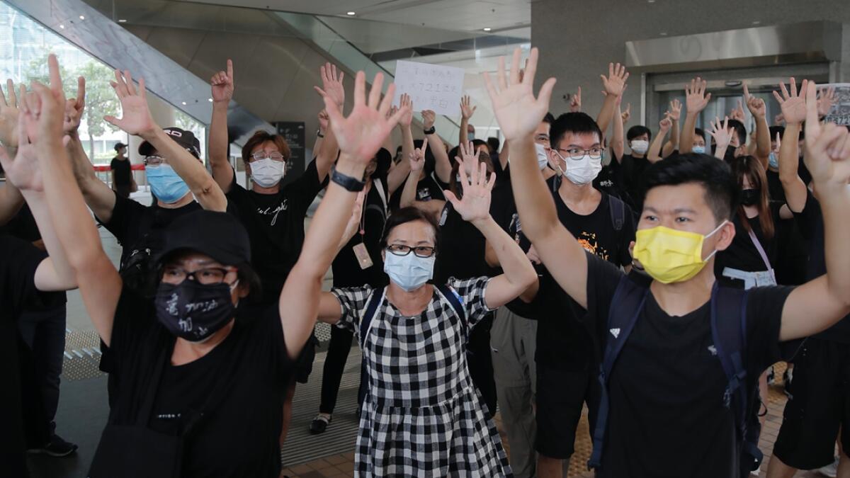 Protesters gesture with five fingers, signifying the 'Five demands - not one less' outside a court during a protest in Hong Kong. Hong Kong police arrested 16 people, including two opposition lawmakers, on Wednesday on charges related to anti-government protests last year. Photo: AP
