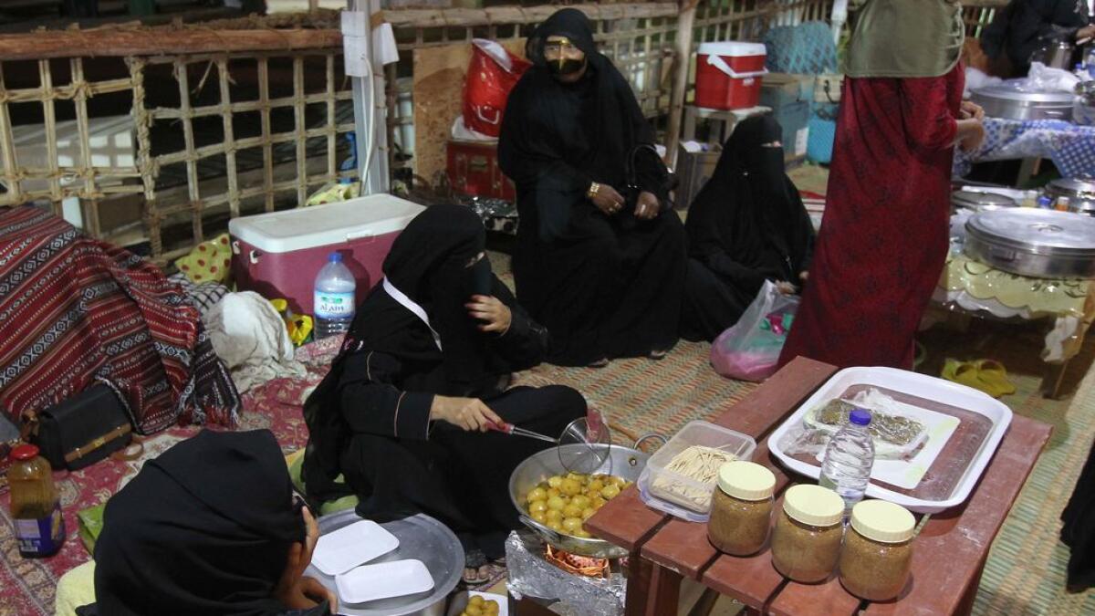 Emirati women preparing traditional dishes at the Mirfa festival.