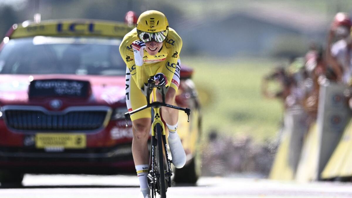 Team UAE Emirates' Tadej Pogacar wearing the overall leader's yellow jersey crosses the finish line during the 20th stage of the 108th edition of the Tour de France.— AFP