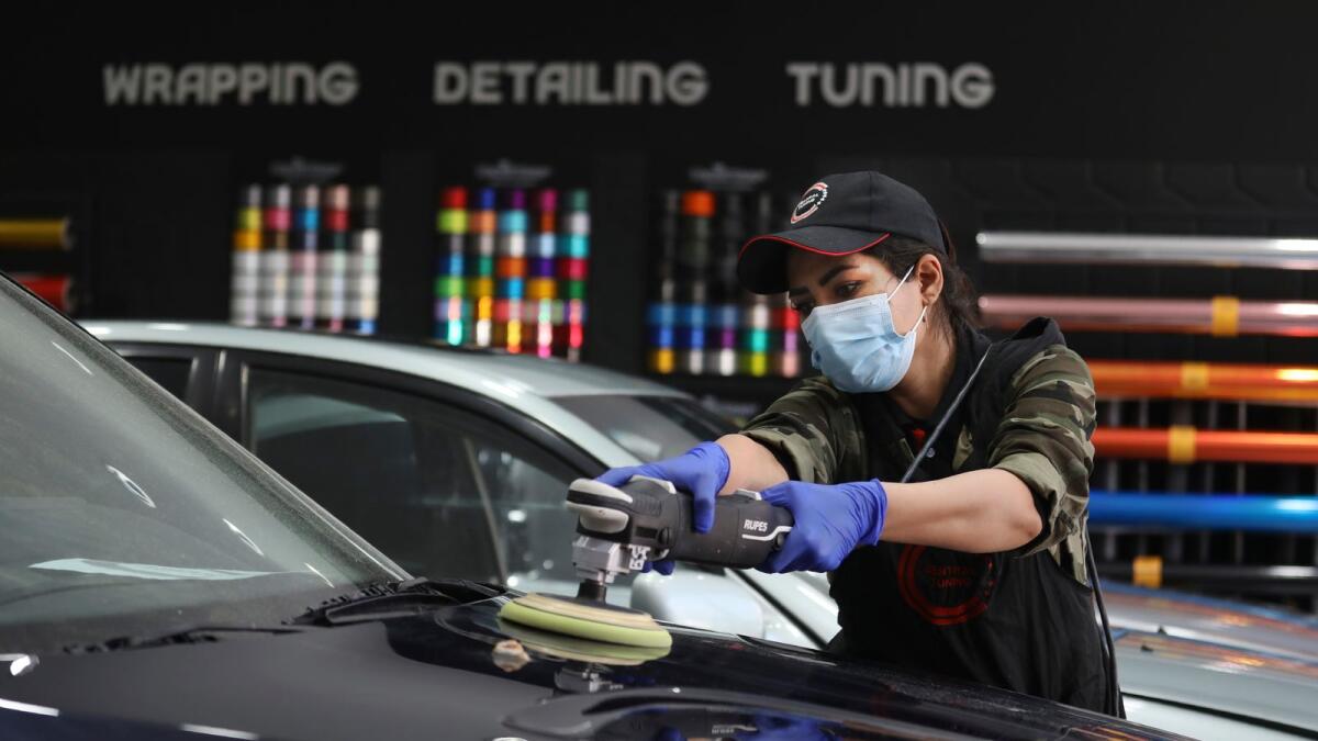Iranian car detailer Maryam Roohani polishes a car at a detailing shop in Tehran.