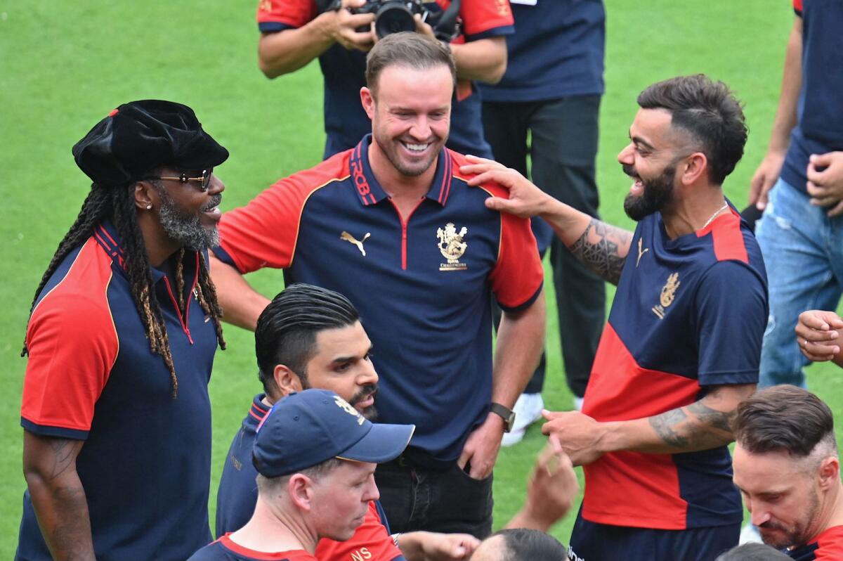 Former Royal Challengers Bengaluru players Chris Gayle (left) and AB de Villiers (centre) share a light moment with Virat Kohli during RCB Unbox at the M Chinnaswamy Stadium. - AFP