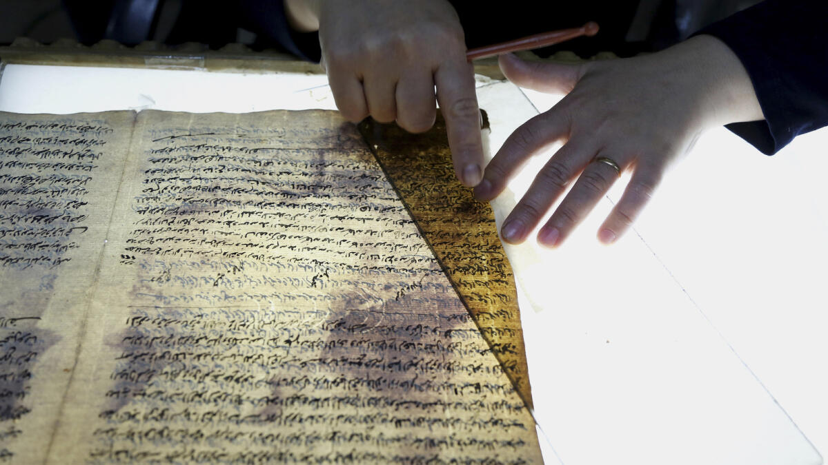 A member of the library restoration staff works on a damaged document at the Baghdad National Library in Iraq.