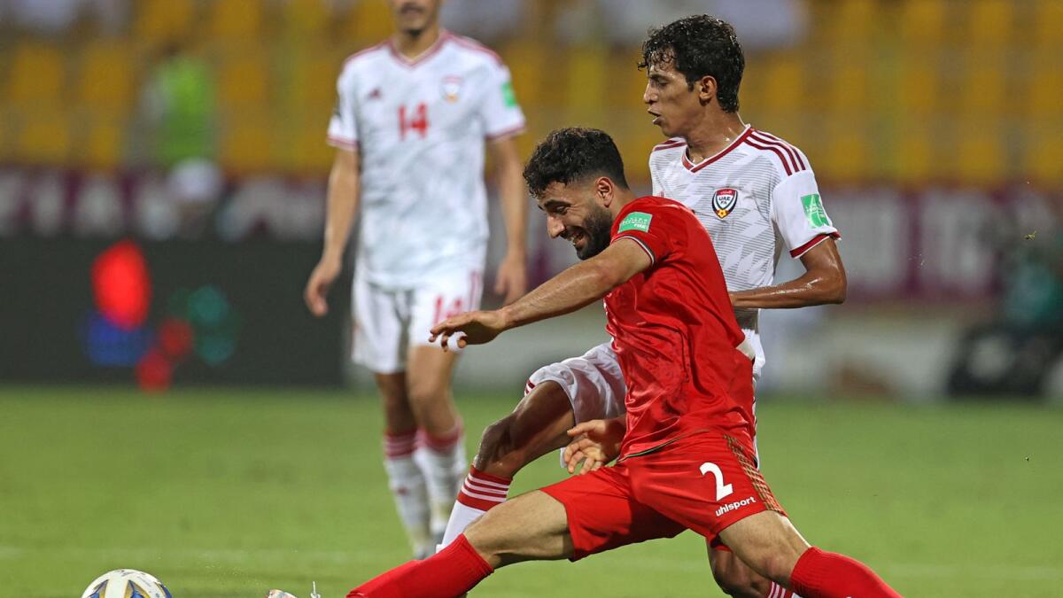 Iran’s defender Sadegh Moharrami (left) vies for the ball with UAE’s midfielder Abdulla Hamad during the World Cup qualifying match. — AFP