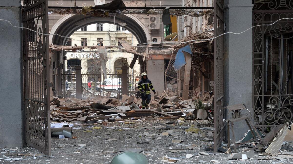 A firefighter walks among damages in a building entrance  after the shelling by Russian forces of Constitution Square in Kharkiv, Ukraine's second-biggest city, on March 2, 2022. Photo: AFP