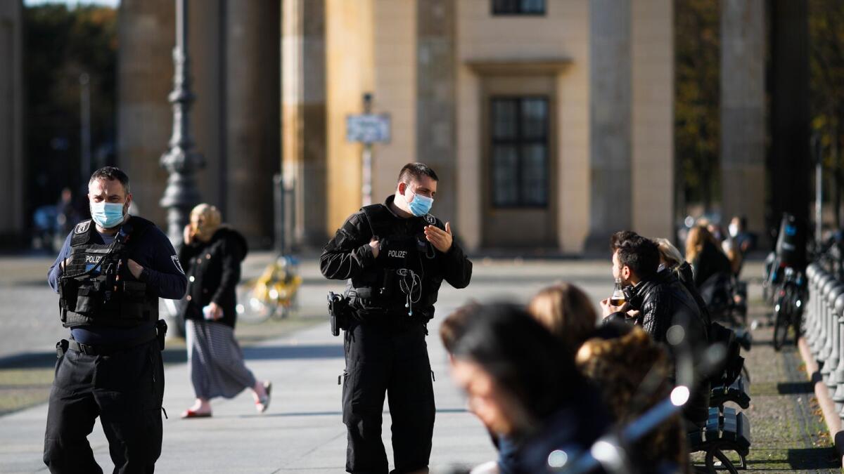Police officers control the mask compulsory at the Pariser Platz in front of the Brandenburg Gate in Berlin, Germany.