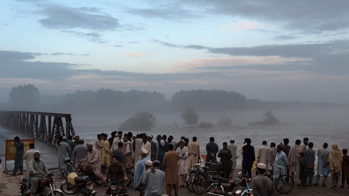 Local residents gather to watch the swallen Charsadda river flow under a bridge following heavy monsoon rainfalls, on the outskirts of Peshawar. More than 100 Pakistanis died in August because of the monsoon, which has also destroyed more than 1,000 homes. Photo: AFP