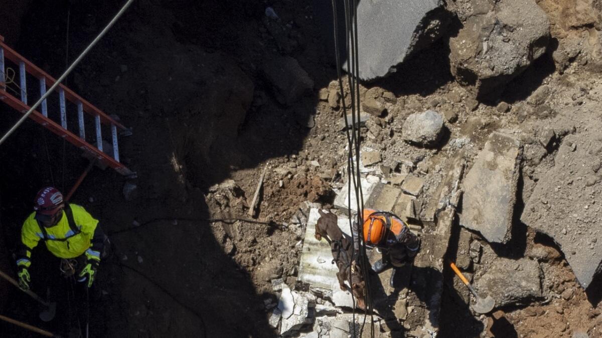 Rescuers search for victims inside a sinkhole in Villa Nueva.