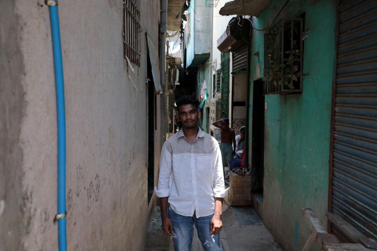 Nizamudin Abdul Rahim Khan, a worker, poses for a photograph in an alley at a slum area in Mumbai on May 20, 2023. Photo: Reuters