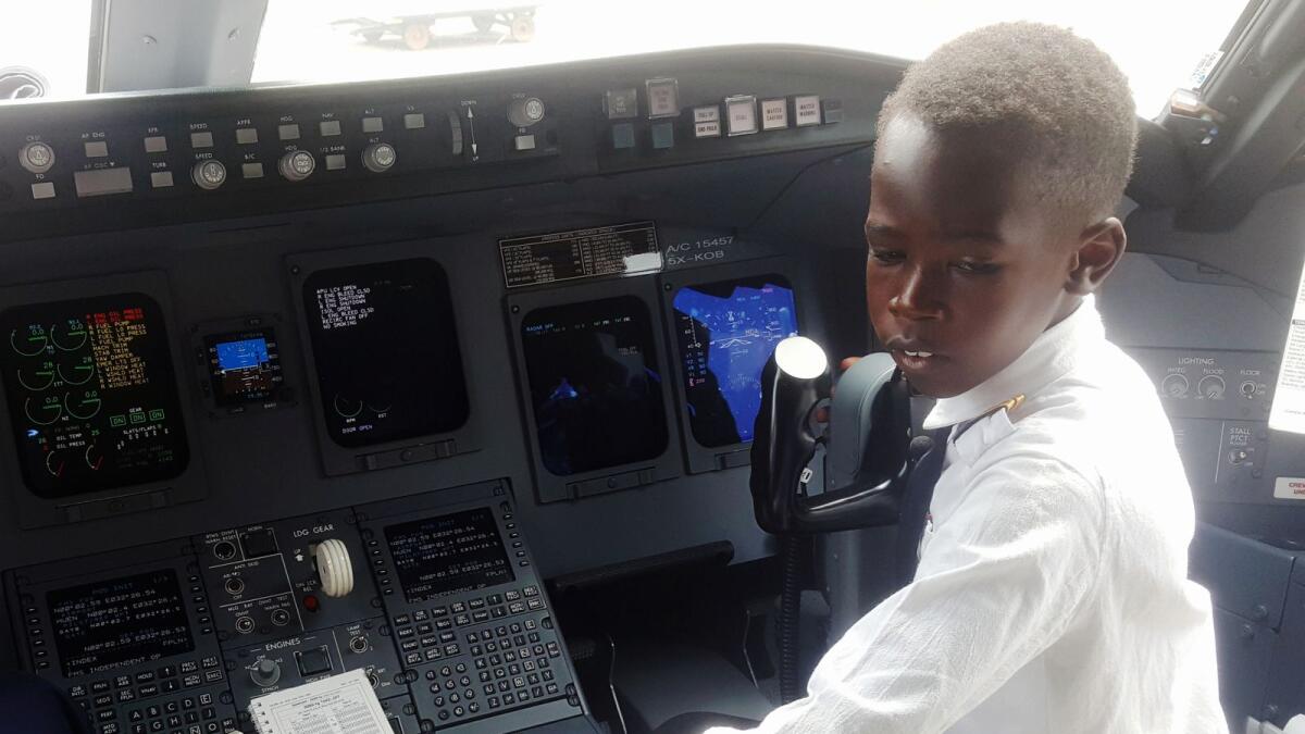 Ugandan 'Captain' Graham Shema, 7, is seen inside the cockpit of a Bombardier CRJ900 aircraft at the Entebbe International Airport, in Entebbe Uganda on December 17.