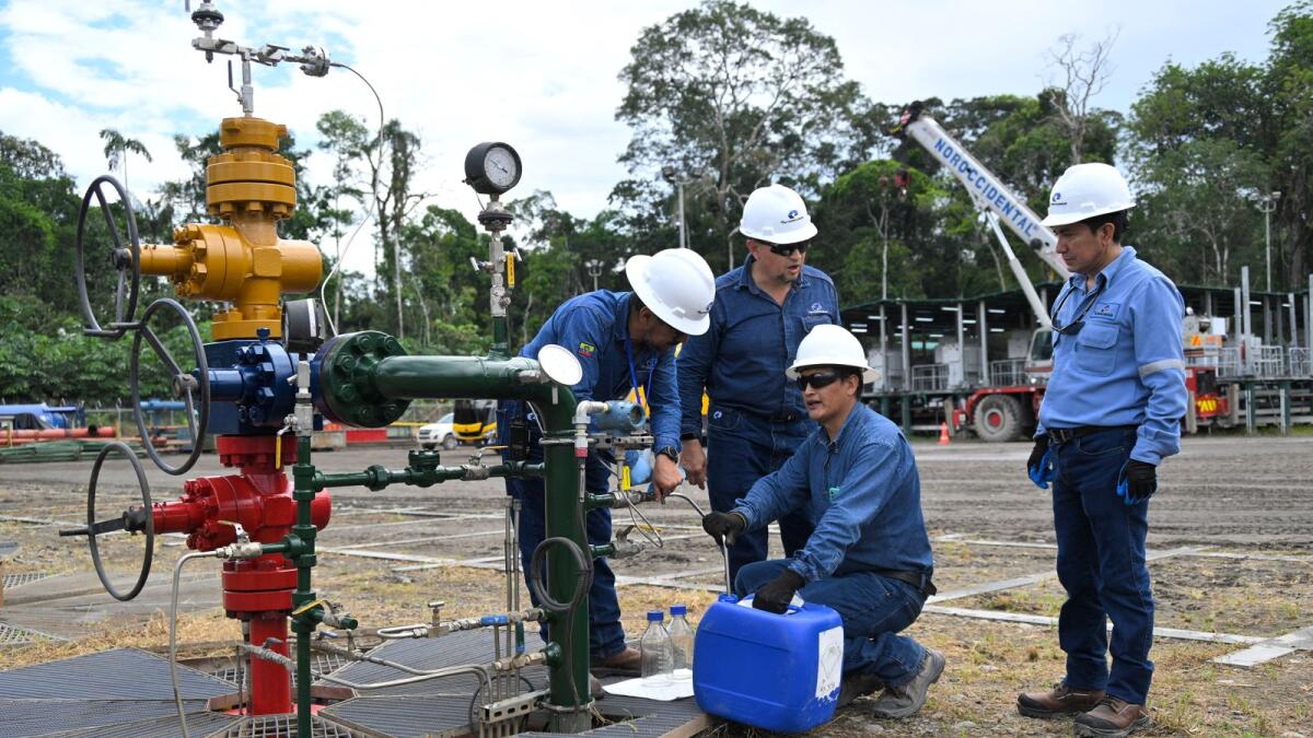 فنيون يأخذون عينات من النفط الخام من بئر نفط في حقل إيشبينغو في متنزه ياسوني الوطني، شمال شرق الإكوادور.  – وكالة فرانس برس