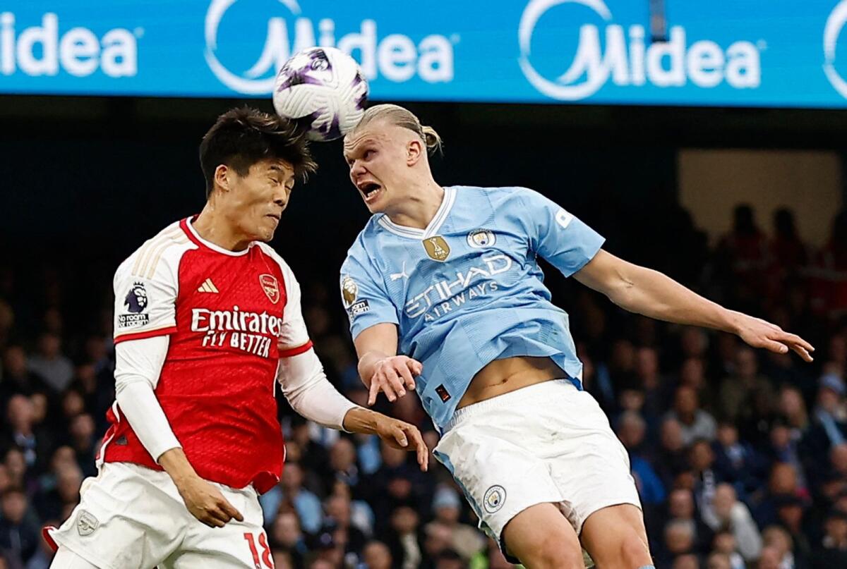 Arsenal's Takehiro Tomiyasu vies for the ball with Manchester City's Erling Braut Haaland. — Reuters