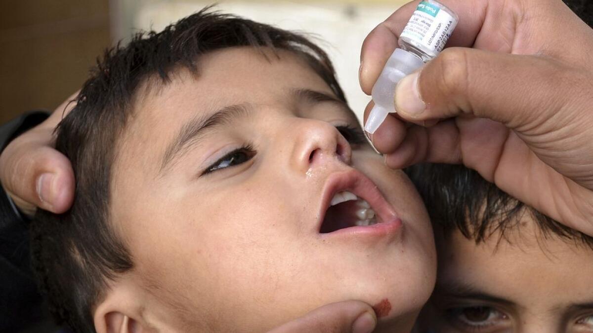A Pakistani health worker gives polio vaccine to a child in Quetta, Pakistan, 