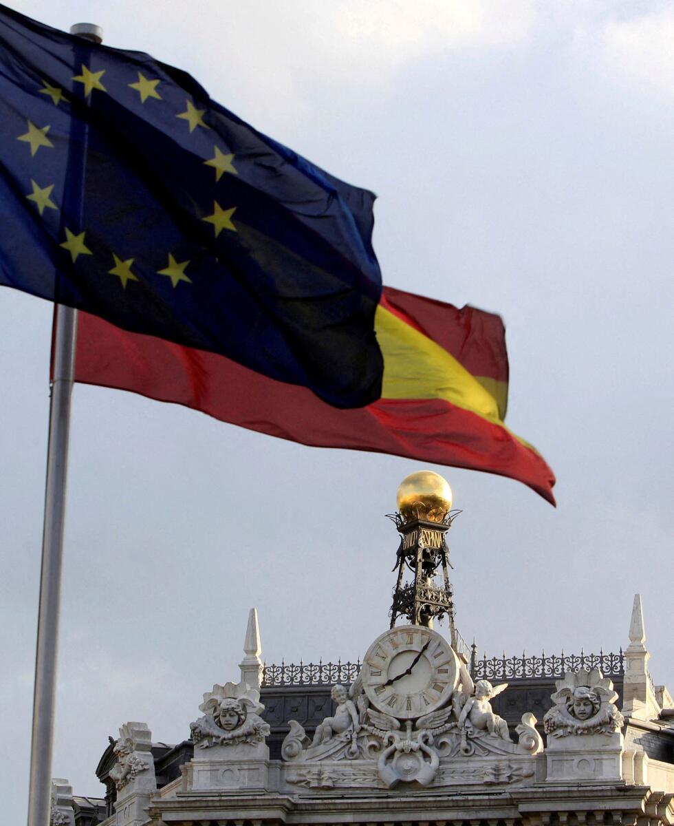 A European Union and a Spanish flag are seen beside the Bank of Spain building in central Madrid. - Reuters file