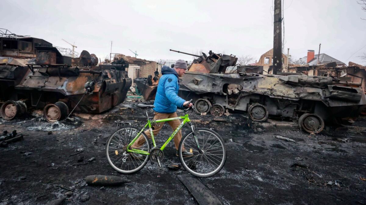A man walks past the remains of Russian military vehicles in Bucha, close to the capital Kyiv. — AP