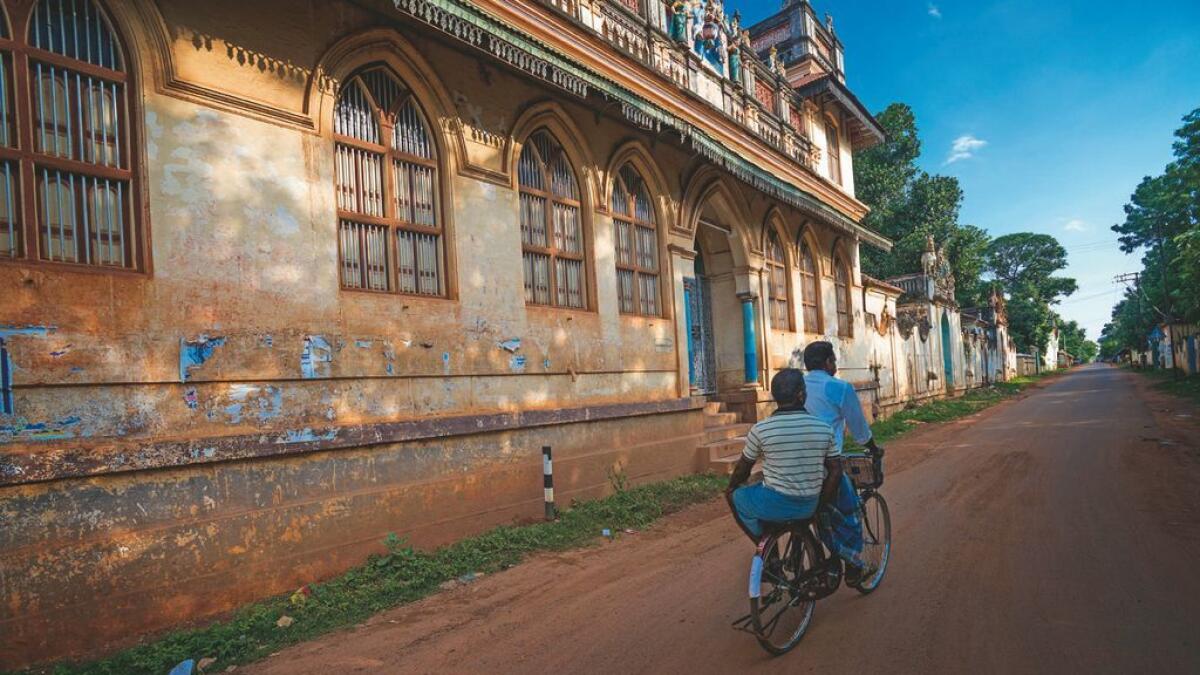 OLD MEETS NEW: Locals cycle past ancient Chettinad mansions in Tamil Nadu
