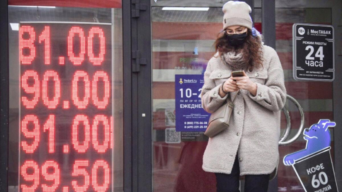 A woman walks past a currency exchange office in central Moscow. — AFP