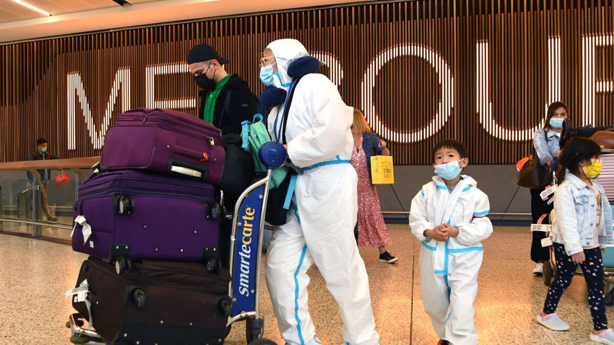 International travellers wearing personal protective equipment (PPE) arrive at Melbourne's Tullamarine Airport on November 29, 2021 as Australia records it's first cases of the Omicron variant of Covid-19. (Photo: AFP)