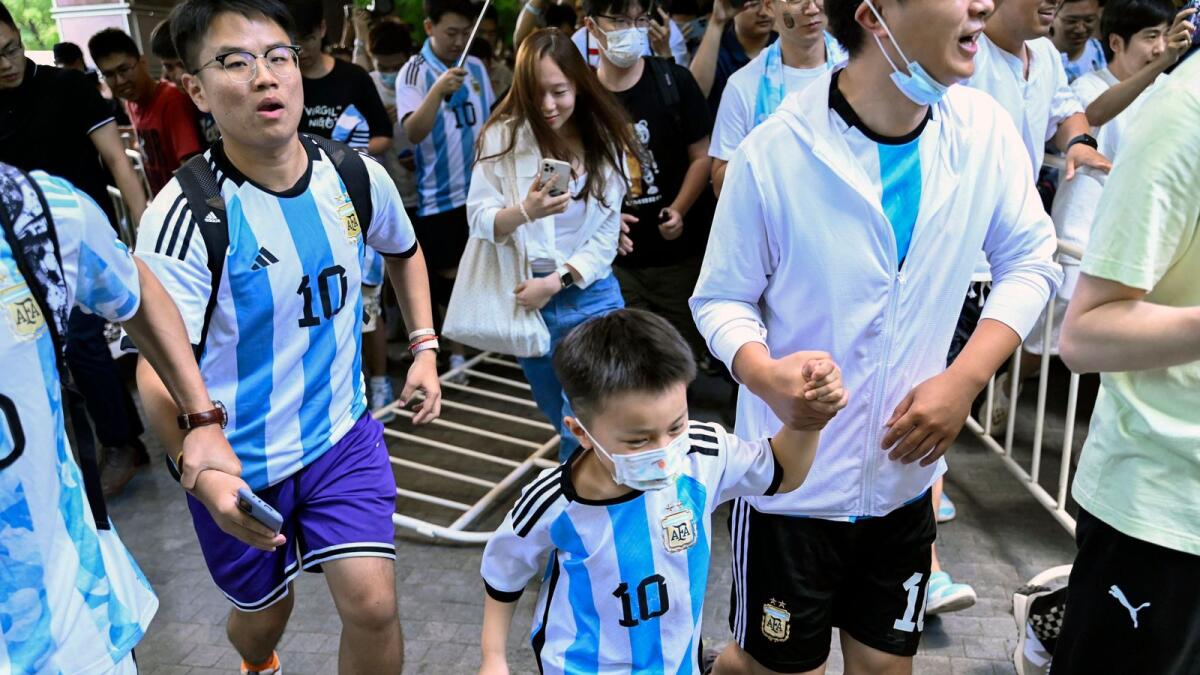 Fans rush to see the arrival of the Argentine national football team outside the Four Seasons Hotel in Beijing. — AFP