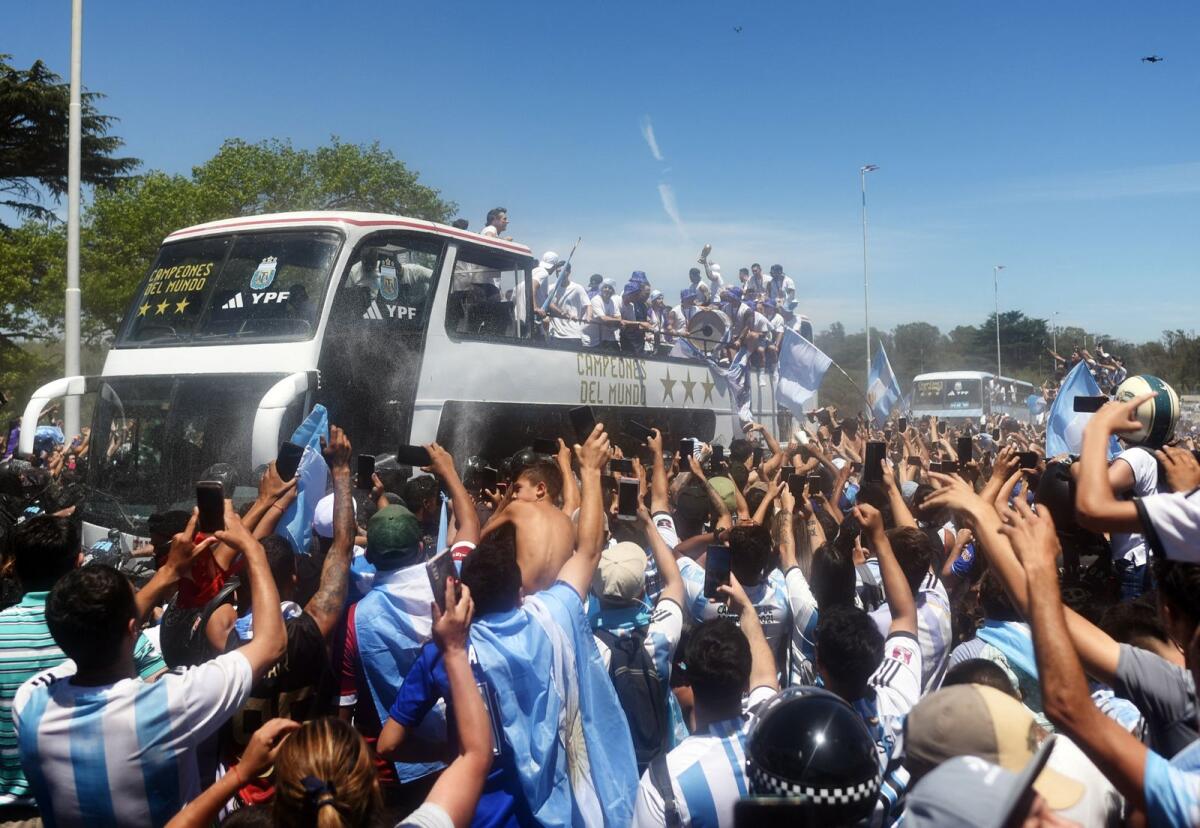 Argentina players are pictured on a bus with the World Cup trophy during the victory parade as fans celebrate. Photo: Reuters