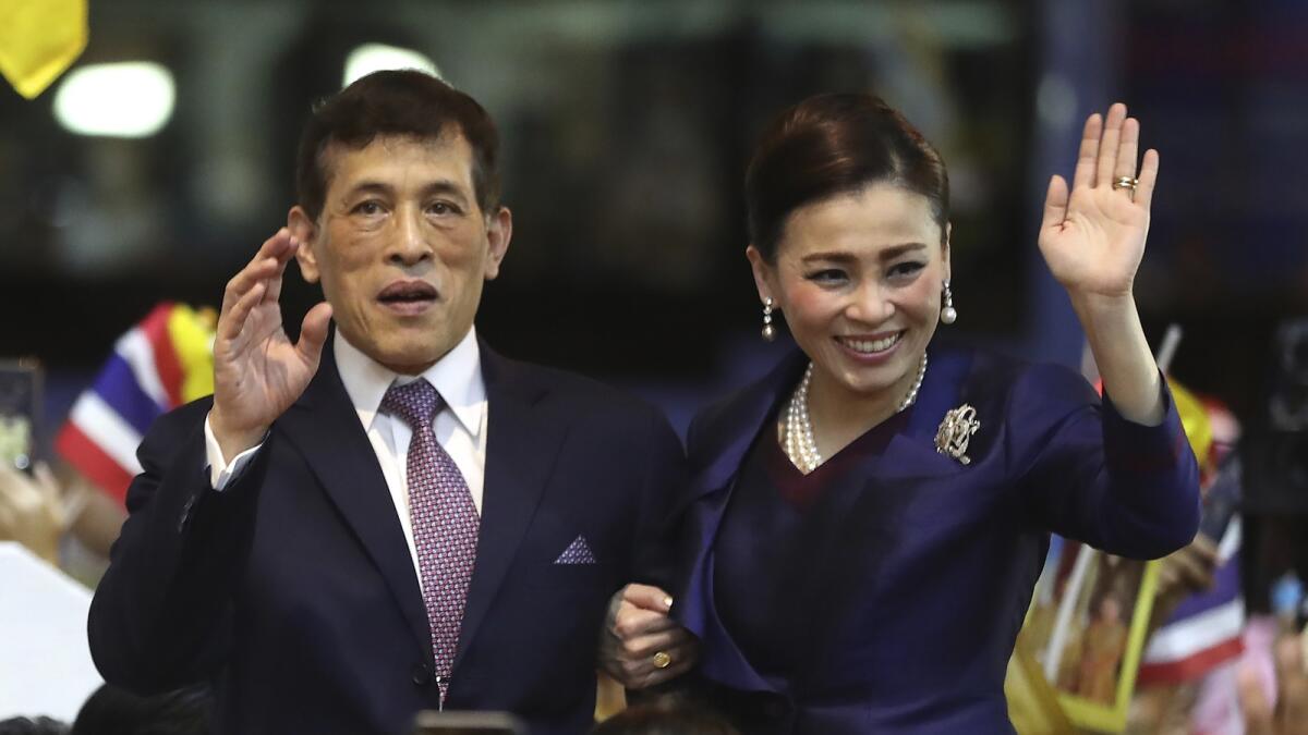 Thai King Maha Vajiralongkorn and Queen Suthida wave to supporters after presiding over the opening of a new mass transit station in Bangkok on November 14, 2020. — AP file