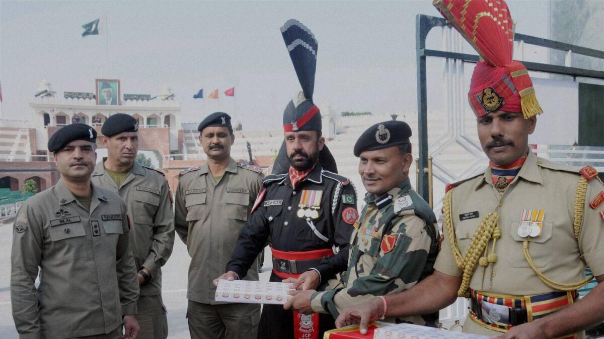 BSF officials offer sweets to Pakistani Rangers officials on the occasion of Diwali festival at Indo-Pak Attari-Wagha border on Wednesday.