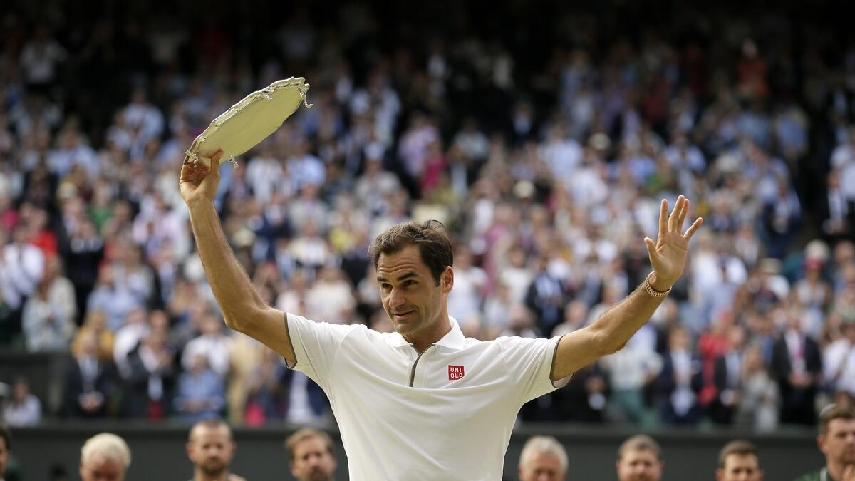 Roger Federer holds the runner up trophy after losing to Serbia's Novak Djokovic in the men's singles final match of the Wimbledon Tennis Championships in London. AP