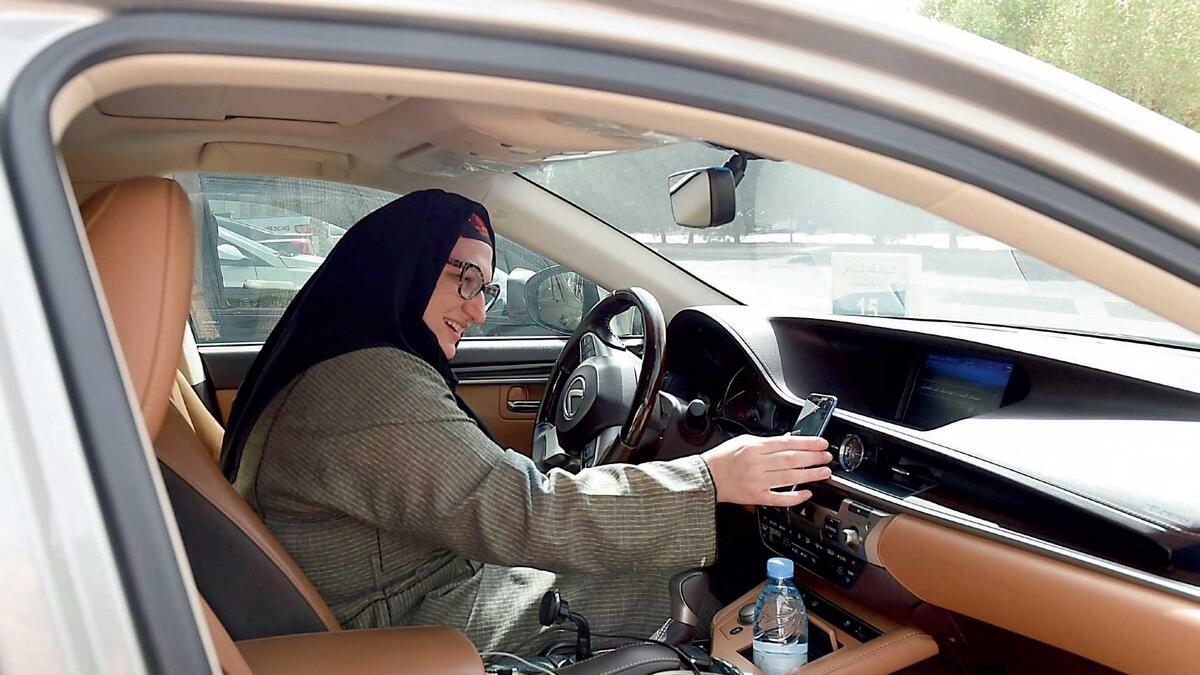 Reem Farahat prepares for a customer shuttle using her car in Riyadh. — AFP