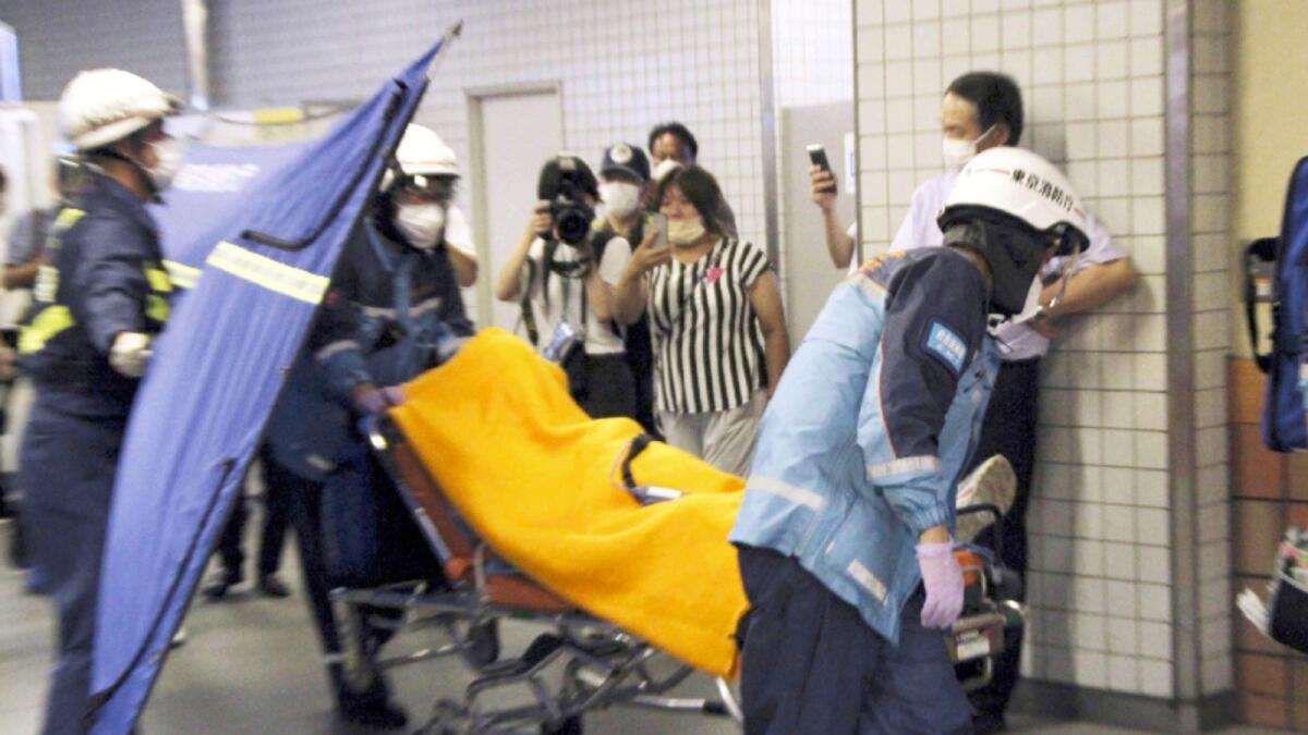 Rescuers carry an injured passenger on  stretcher at Soshigaya Okura Station after a man with a knife attacked passengers on a commuter train in Tokyo. Photo: AP