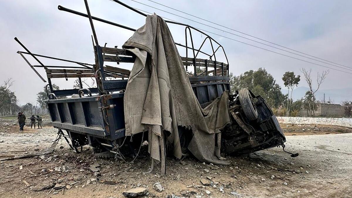 Paramilitary soldiers stand guard in front of the wreckage of a police truck at the site of a roadside bomb blast in Bajaur district, around 14 km from the border with Afghanistan on January 8, 2024.  — AFP file