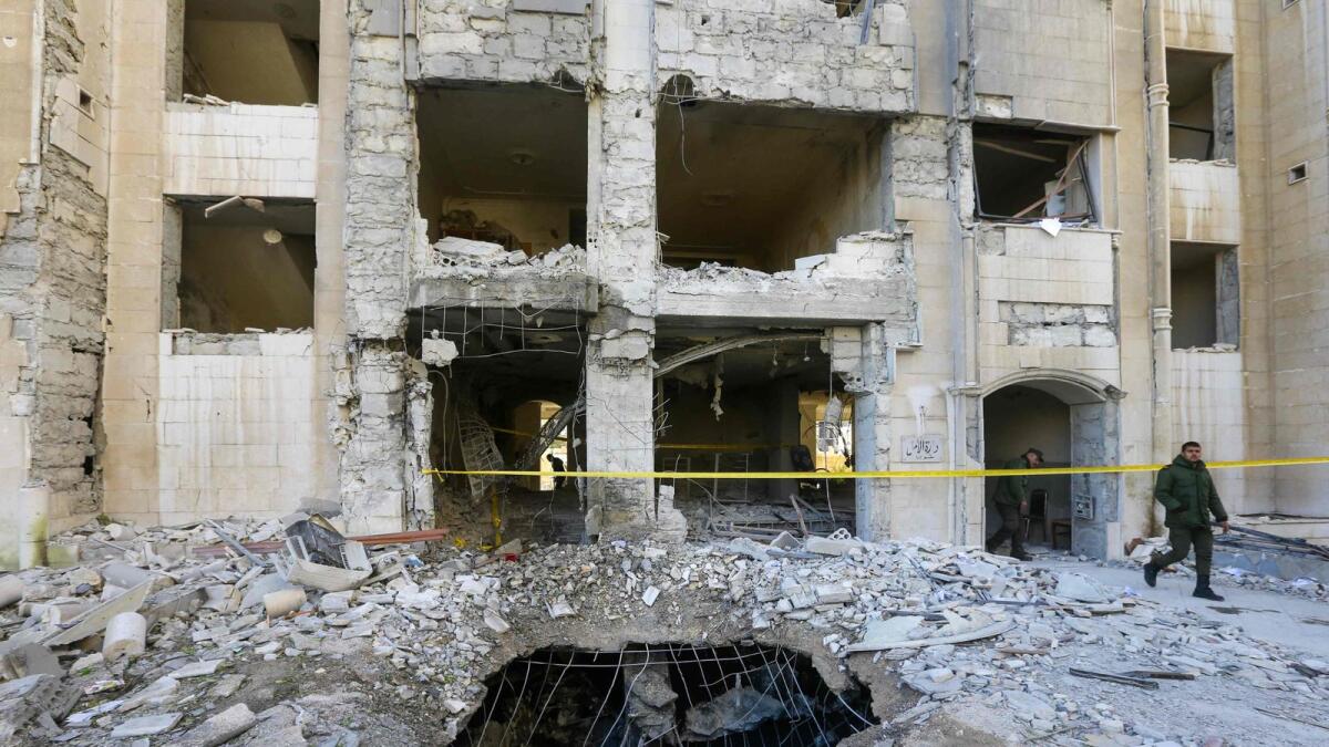 Syrian security forces members inspect a building damaged in a reported Israeli missile strike in Damascus on February 19, 2023. -- AFP file