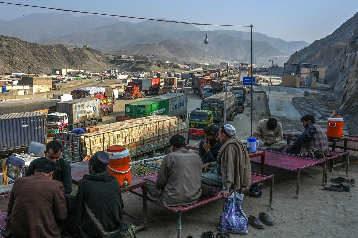 Drivers take rest as stranded trucks are pictured near the Pakistan-Afghanistan border in Torkham on January 16, 2024. — AFP