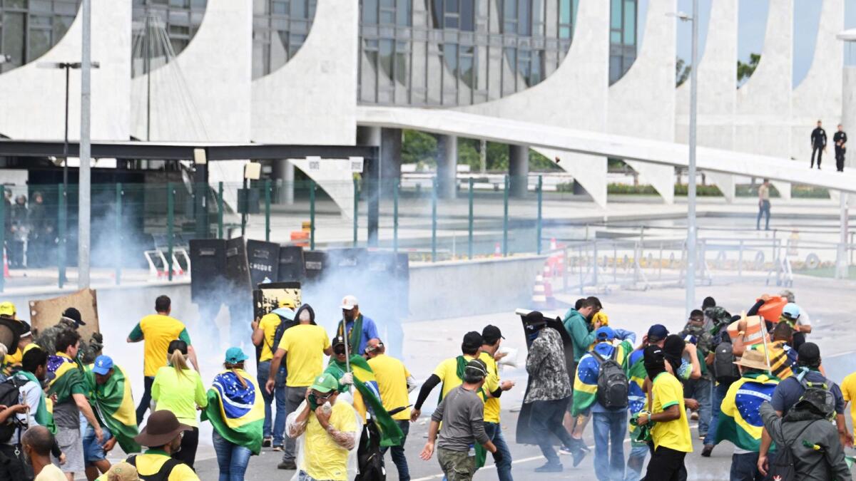 Supporters of Brazilian former president Jair Bolsonaro clash with the police during a demonstration outside the Planalto Palace in Brasilia on Sunday. — AFP