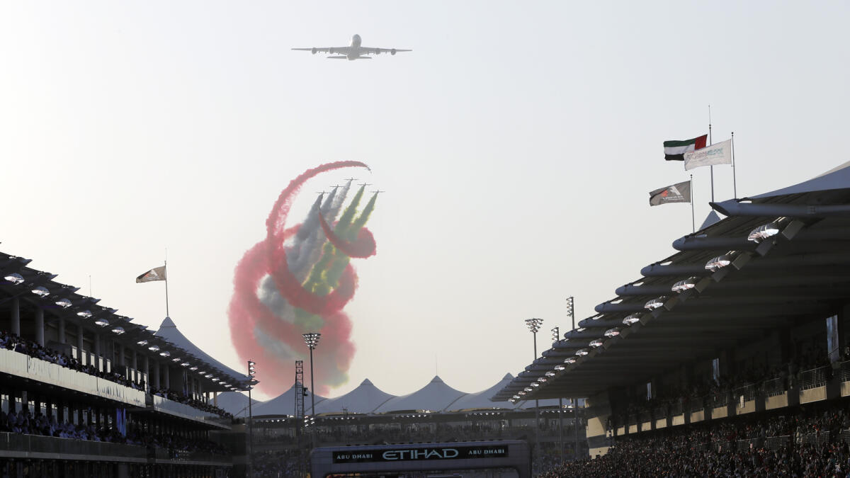 Al Fursan airshow drapes the skyline in the UAE National colours as it  flies above the Grandstands. — KT photo By Ryan Lim