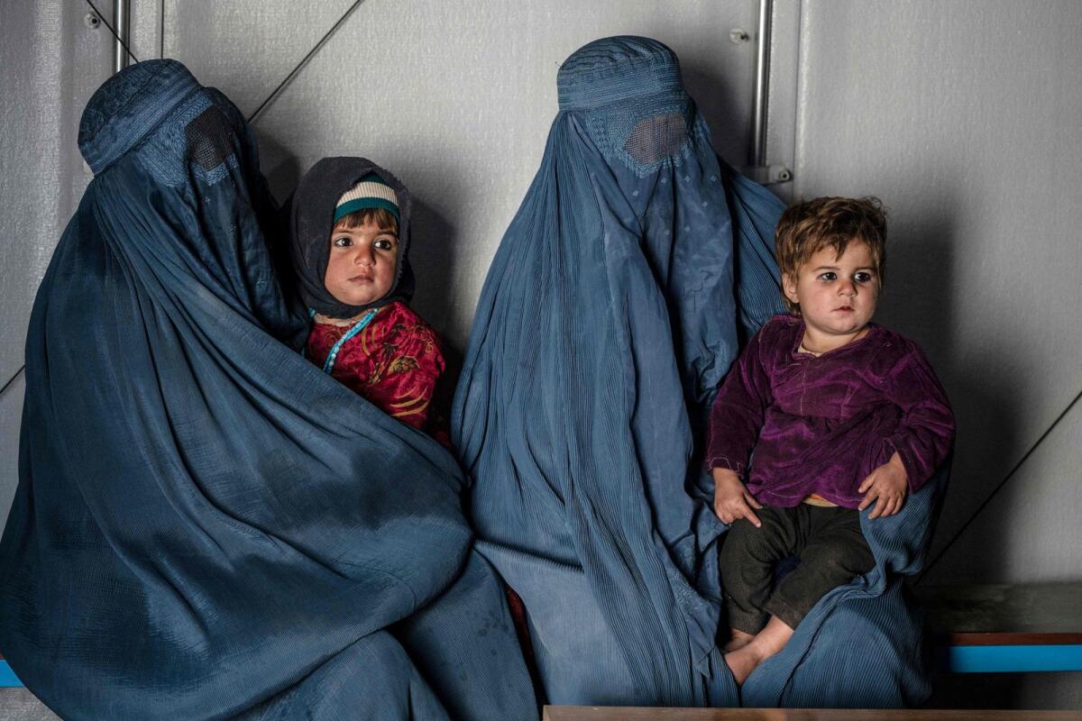 Afghan burqa-clad women and children refugees deported from Pakistan in a counselling room at the United Nations High Commissioner for Refugees (UNHCR) camp on the outskirts of Kabul. — AFP