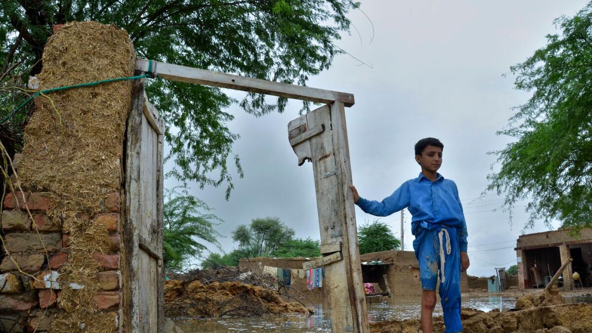 A boy stands in his partially damage home caused by flooding in a district of Pakistan's southwestern province. –AP