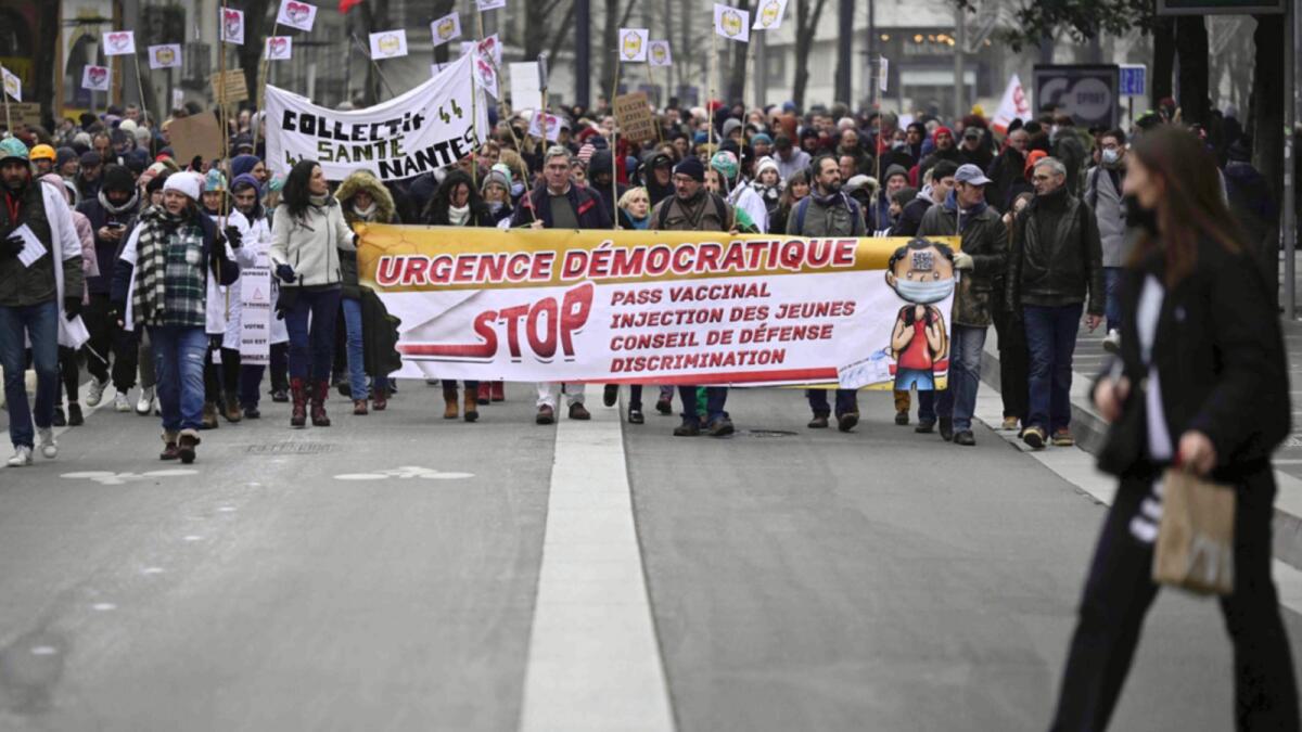 Protesters walk behind a banner reading 'Democratic urgence, stop the vaccine pass' during a demonstration to protest against the health pass and Covid-19 vaccines in Nantes, western France. — AFP