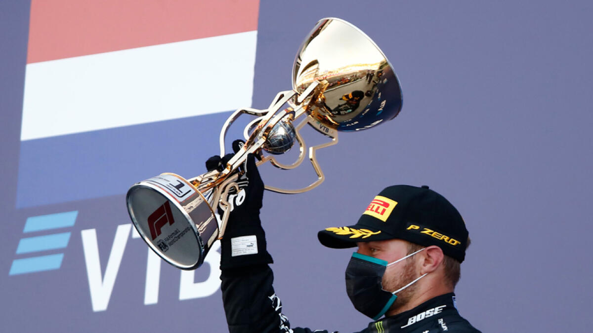 Mercedes' driver Valtteri Bottas celebrates on the podium after winning the Russian Grand Prix. - AFP